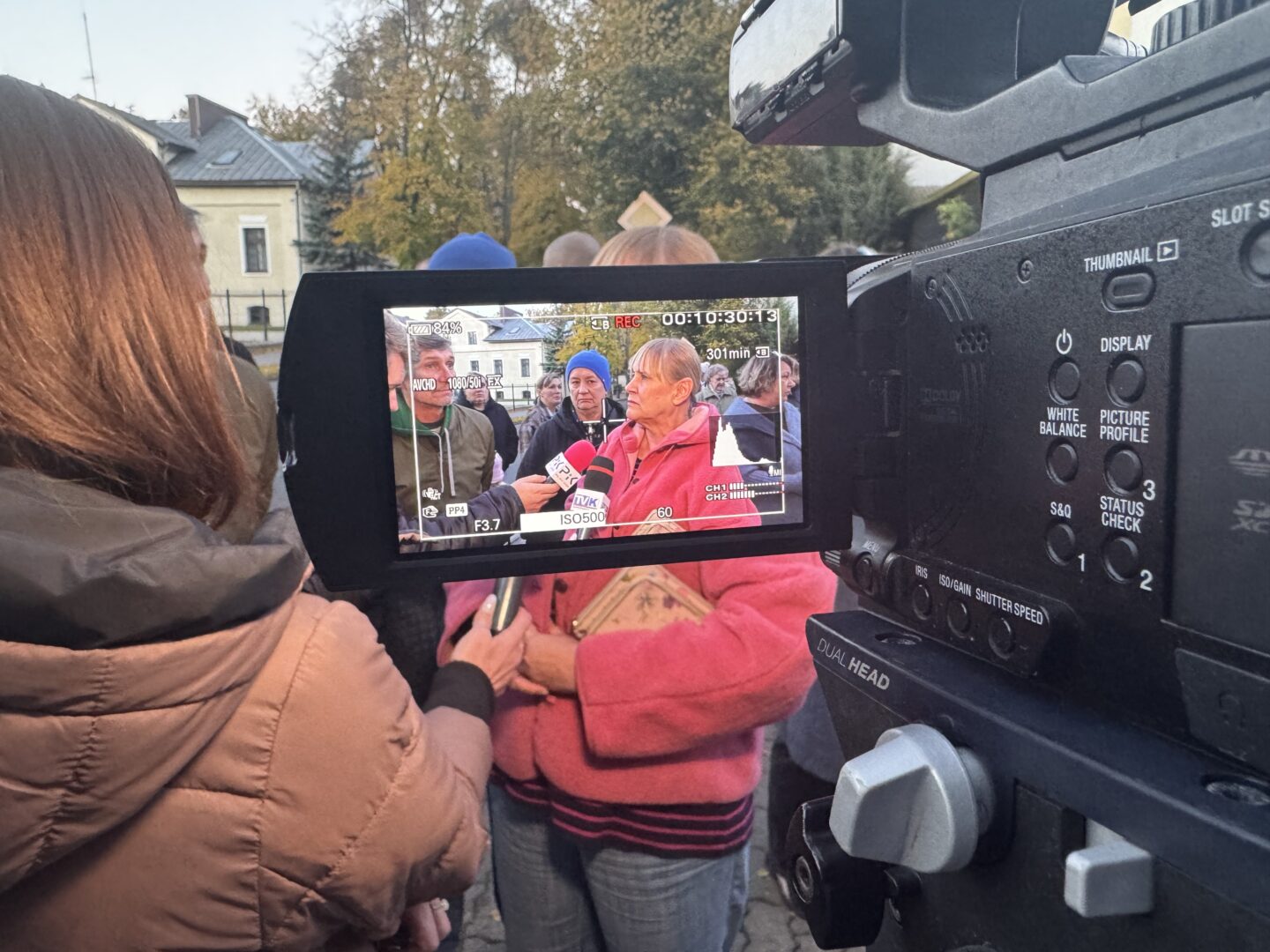 Mieszkanka Ciechocinka rozmawia z dziennikarzami; rozmowę widać na ekranie kamery.